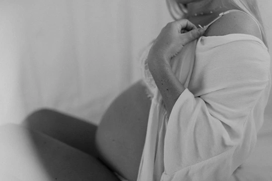 Close-up of a medical professional performing an obstetric ultrasound on a pregnant woman.