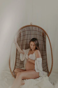 A prenatal chiropractor supporting a pregnant mother with a soothing spinal adjustment in her living room.