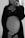 A black and white photo of a pregnant woman standing, wearing a lace bra and partially open robe. Her hand rests gently on her stomach, conveying a sense of calm and introspection.