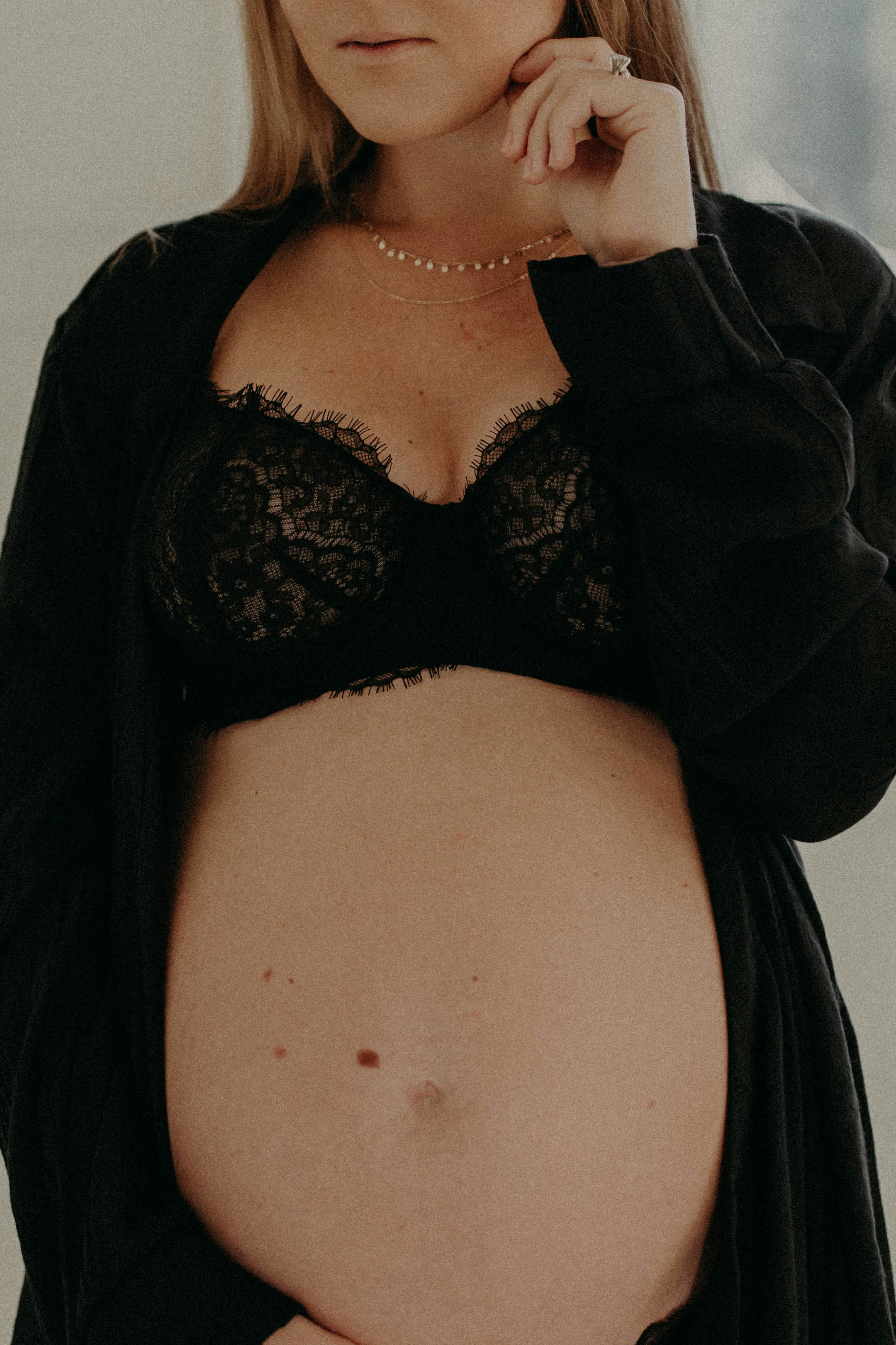 A pregnant woman in a black bra posing for a picture photo pic