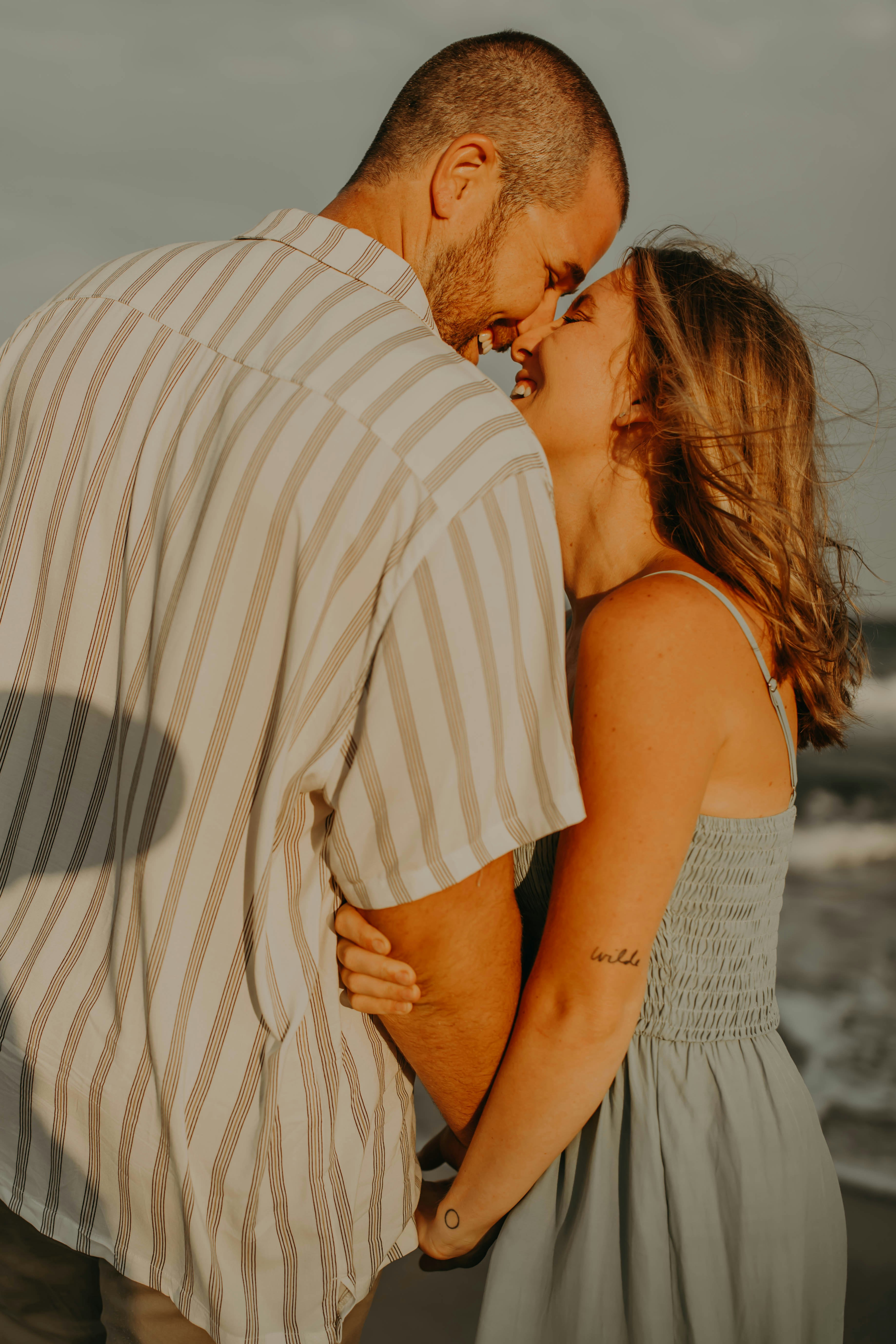 a man and a woman kissing on the beach