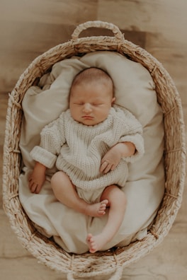 A happy baby sleeping in a cozy frock.