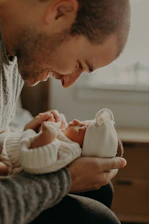 A tender moment capturing a newborn wrapped gently in soft blankets, held by loving parents.