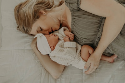 a woman laying on a bed holding a baby
