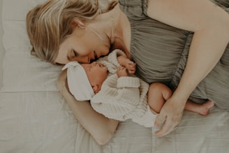 a woman laying on a bed holding a baby