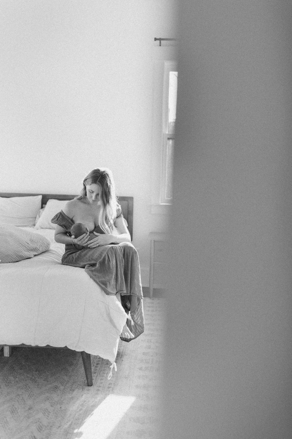 a woman sitting on a bed reading a book