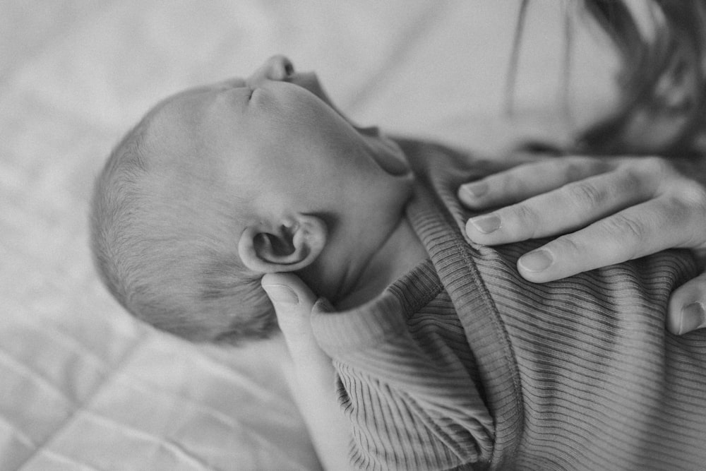 a black and white photo of a woman holding a baby