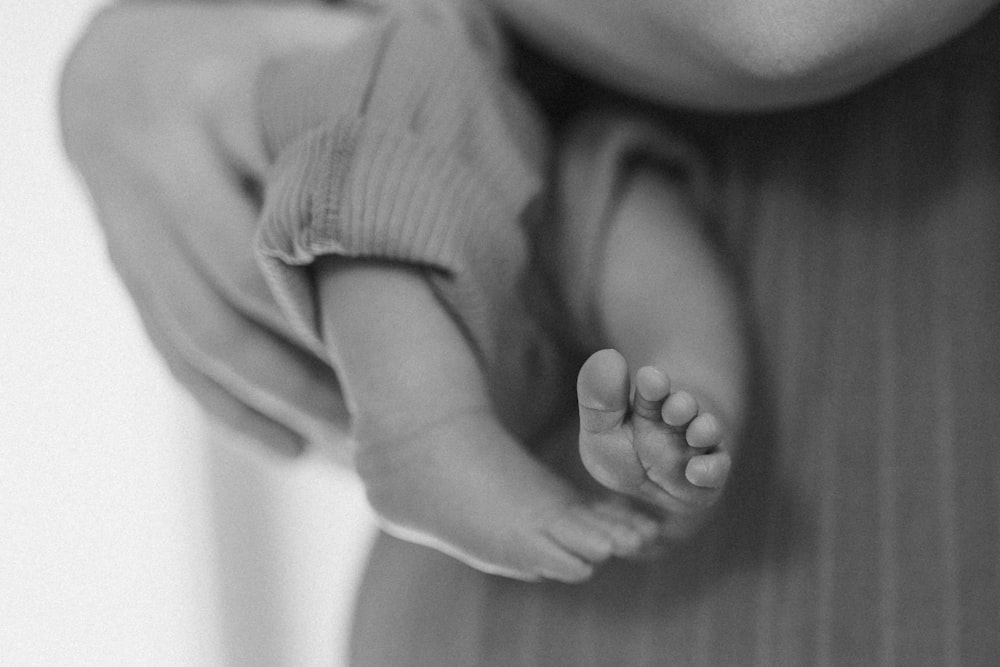 a black and white photo of a person holding a baby