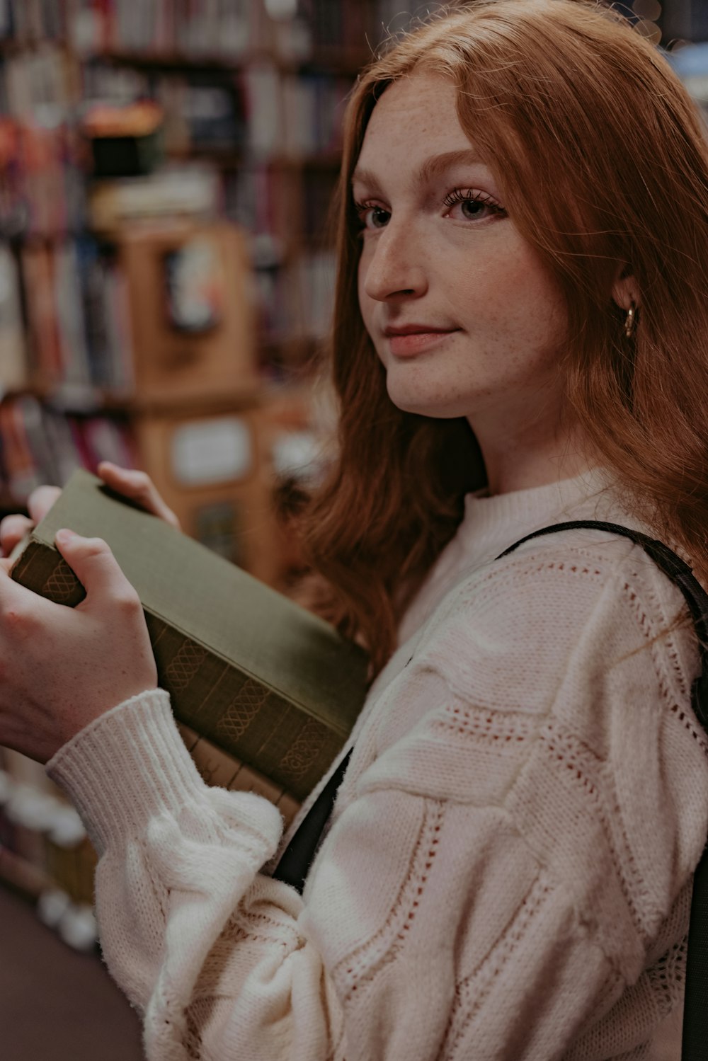 a woman holding a book in a library