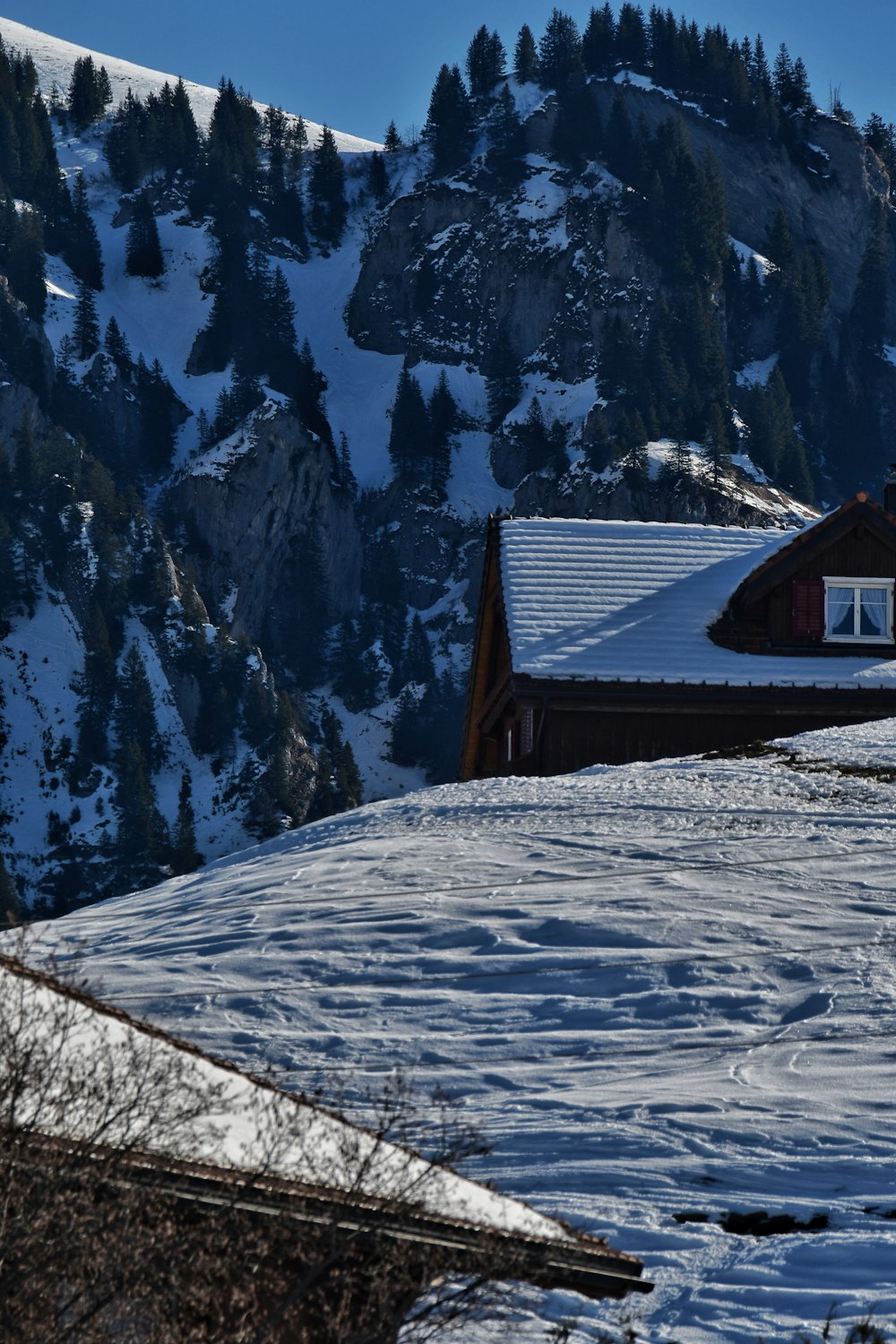 a snow covered mountain with a house in the foreground