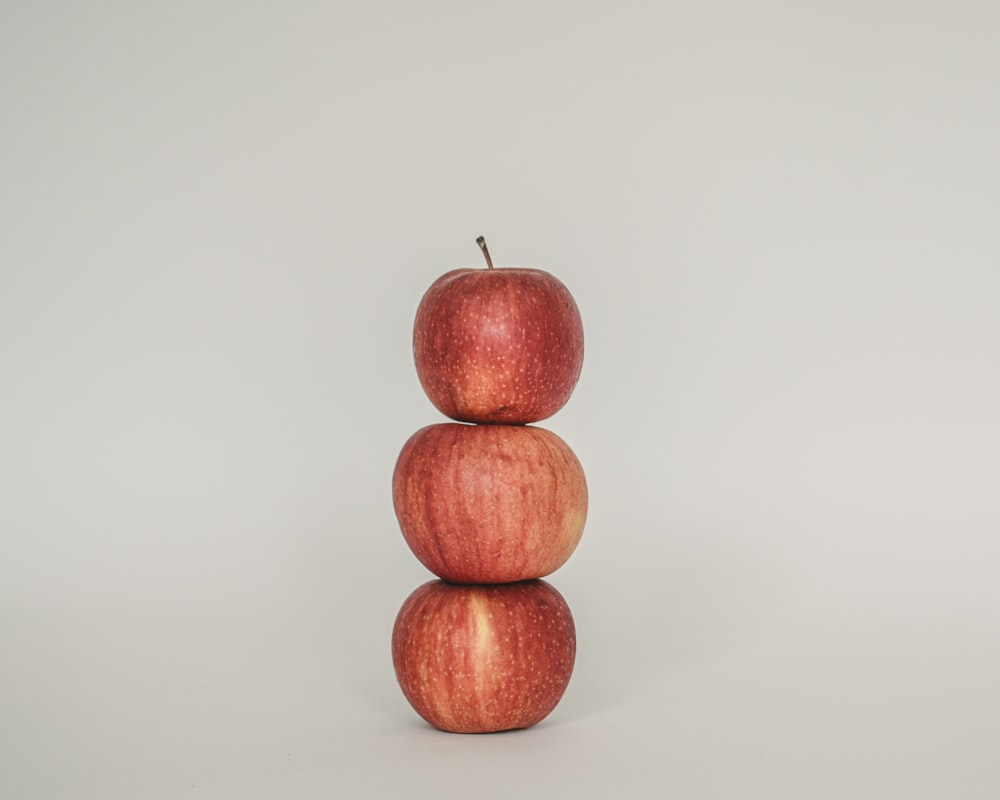 a stack of three apples sitting on top of each other