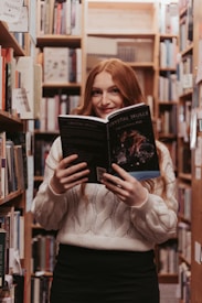 a woman reading a book in a library
