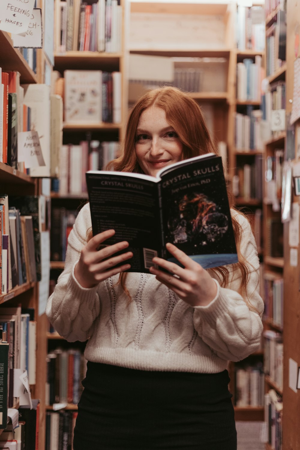 a woman reading a book in a library