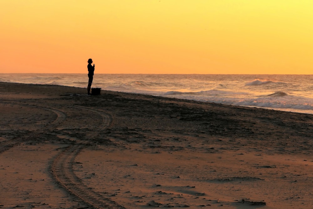 a person standing on a beach next to the ocean