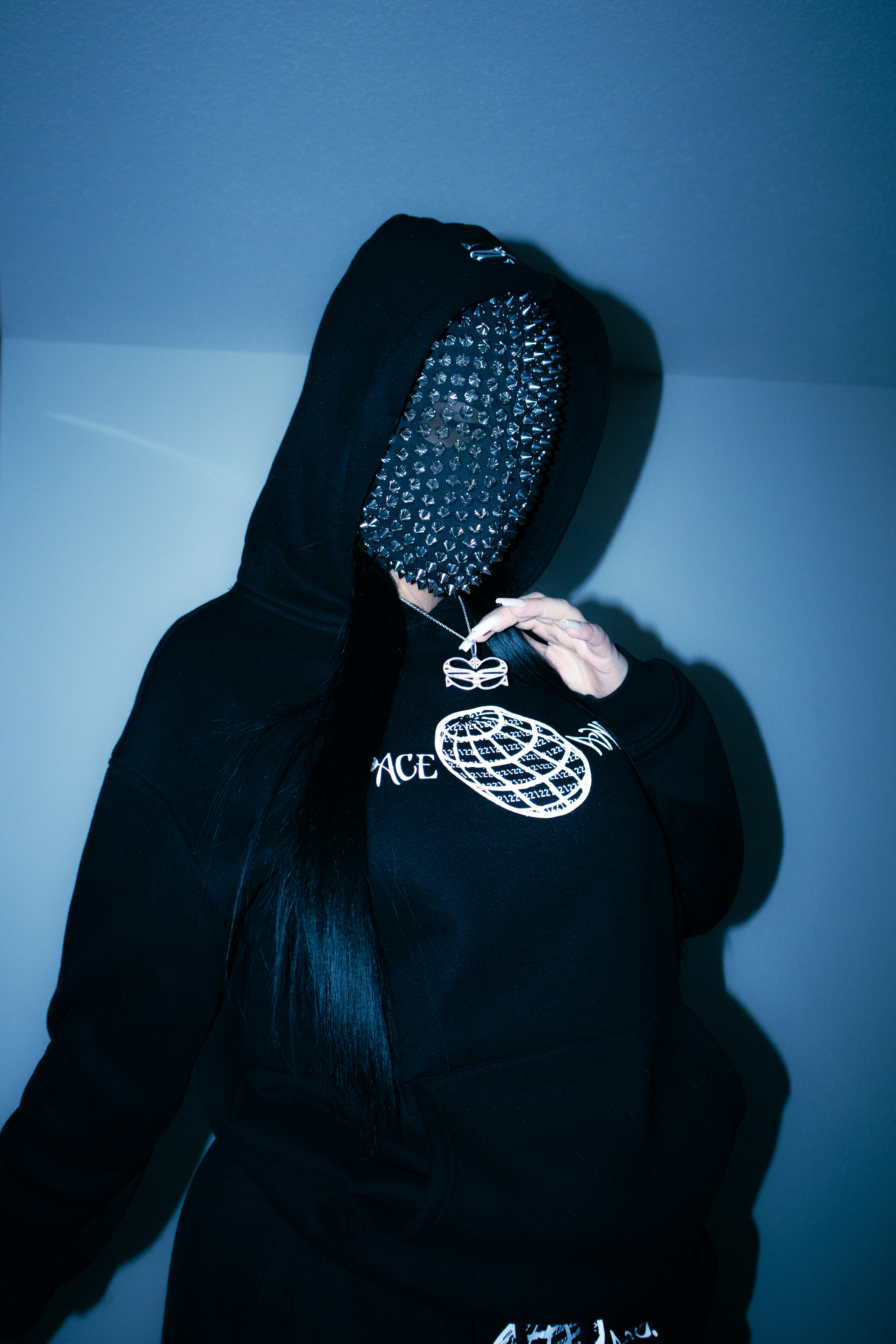a woman in a black hoodie with spikes on her head