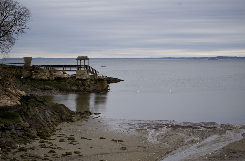 a body of water sitting next to a rocky shore