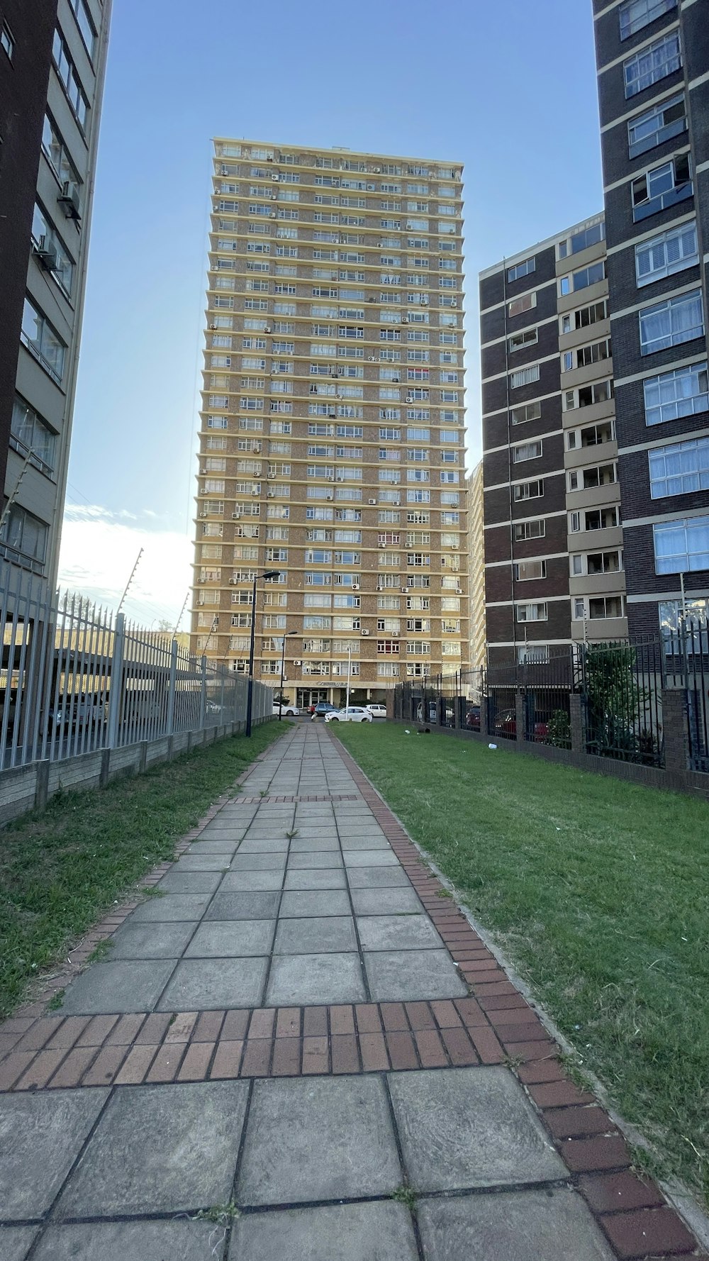 a brick walkway in front of a tall building