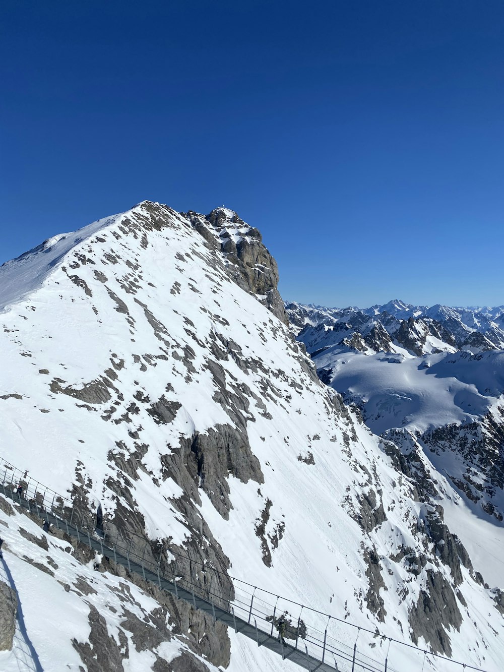 a snow covered mountain with a fence in the foreground