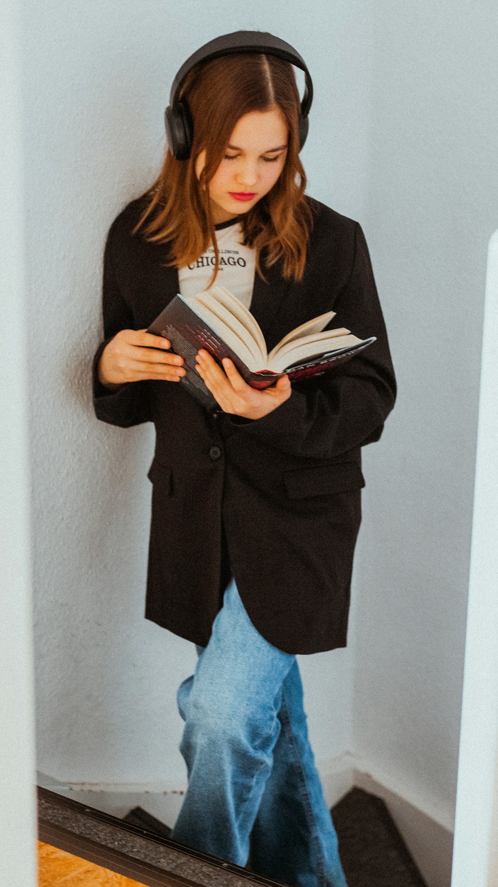 a woman wearing headphones and reading a book