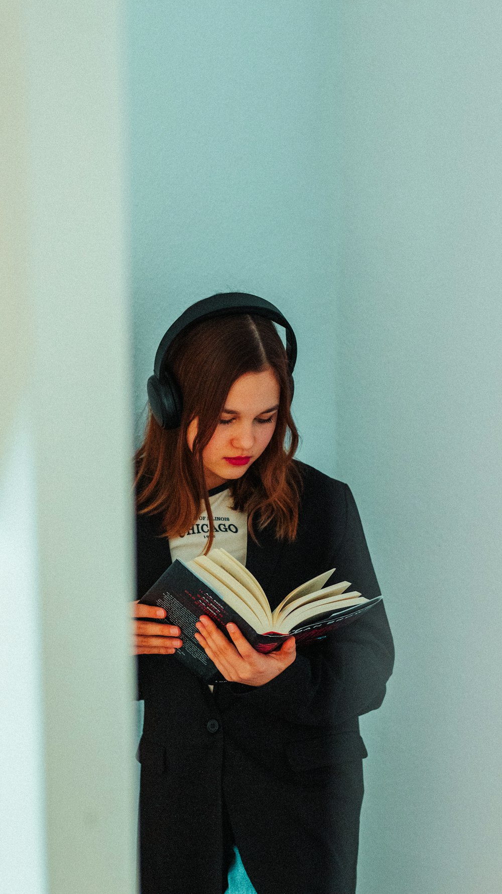 uma mulher usando fones de ouvido está lendo um livro