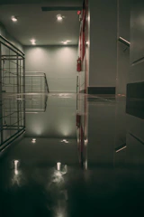 A professional inspecting fire safety equipment in a modern apartment complex hallway.