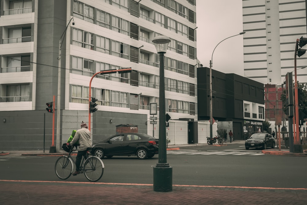 a man riding a bike down a street next to tall buildings