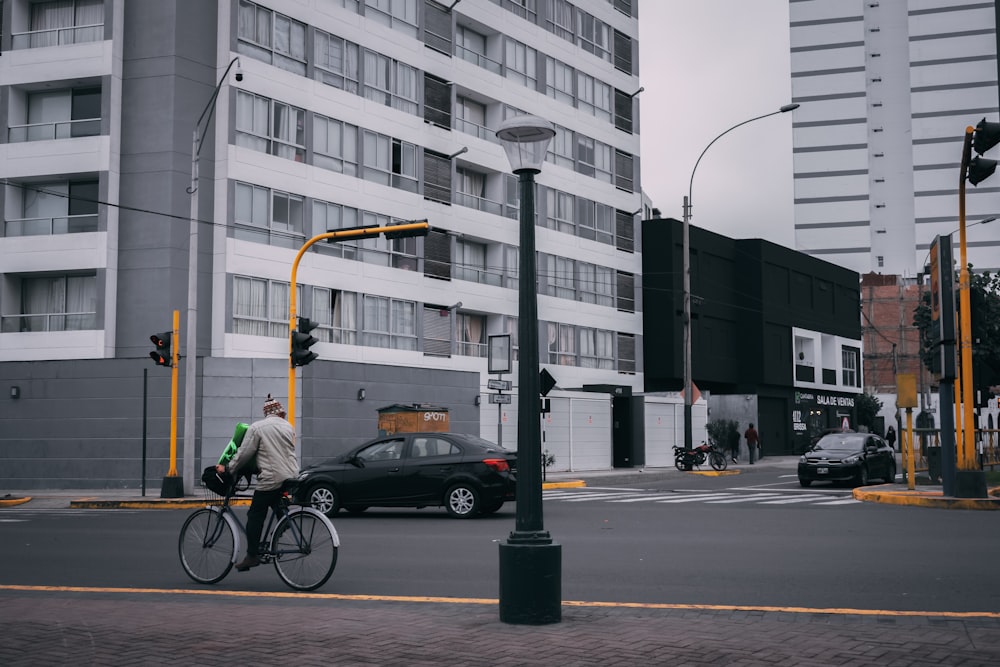 a man riding a bike down a street next to tall buildings