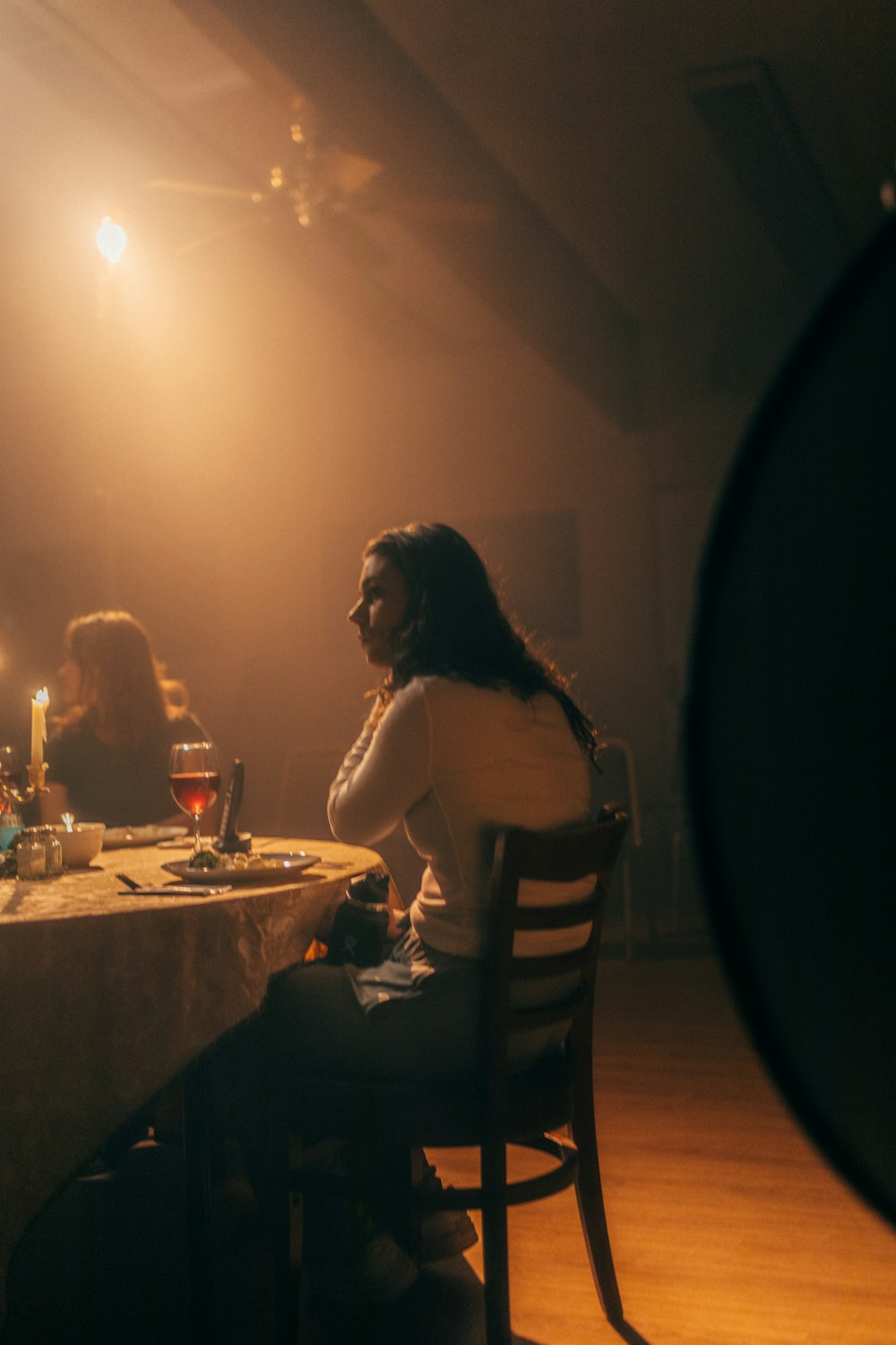 a woman sitting at a table in a dimly lit room