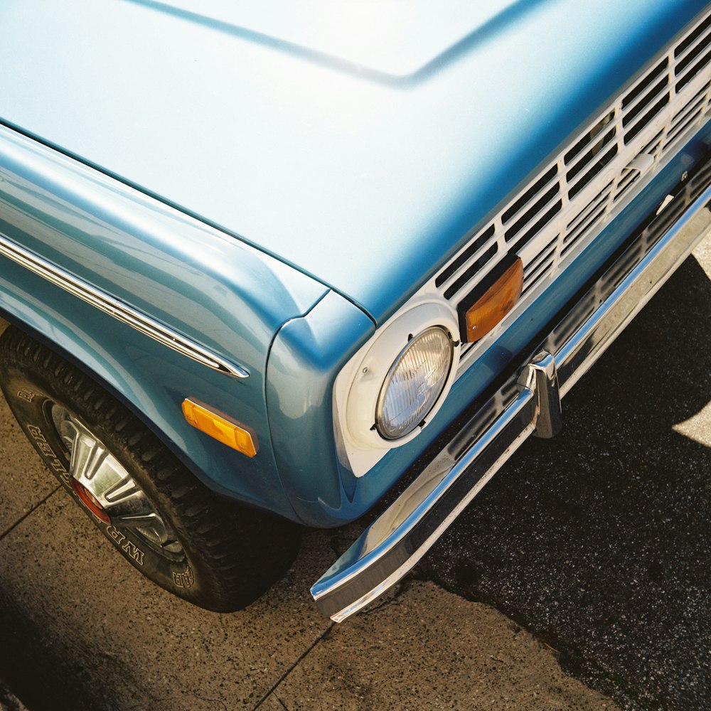 a close up of a blue car parked in a parking lot