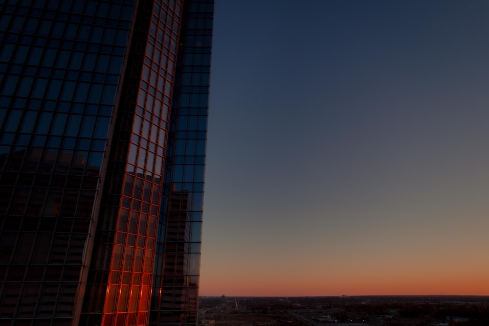 a tall building with a sunset in the background
