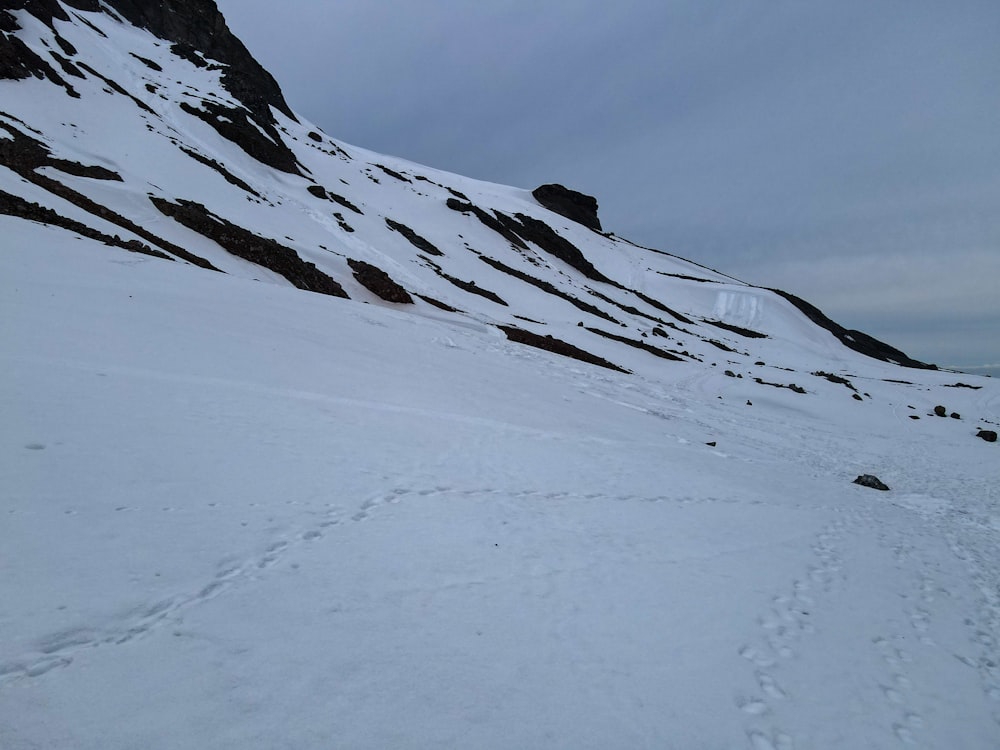 a snow covered mountain with tracks in the snow