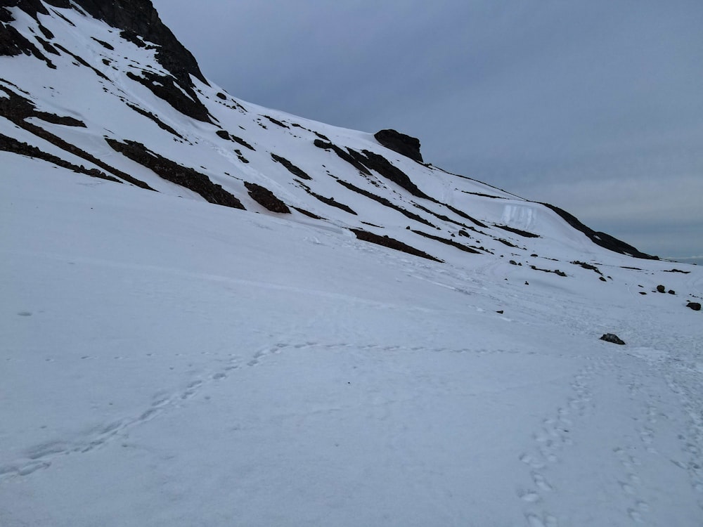 ein schneebedeckter Berg mit Spuren im Schnee