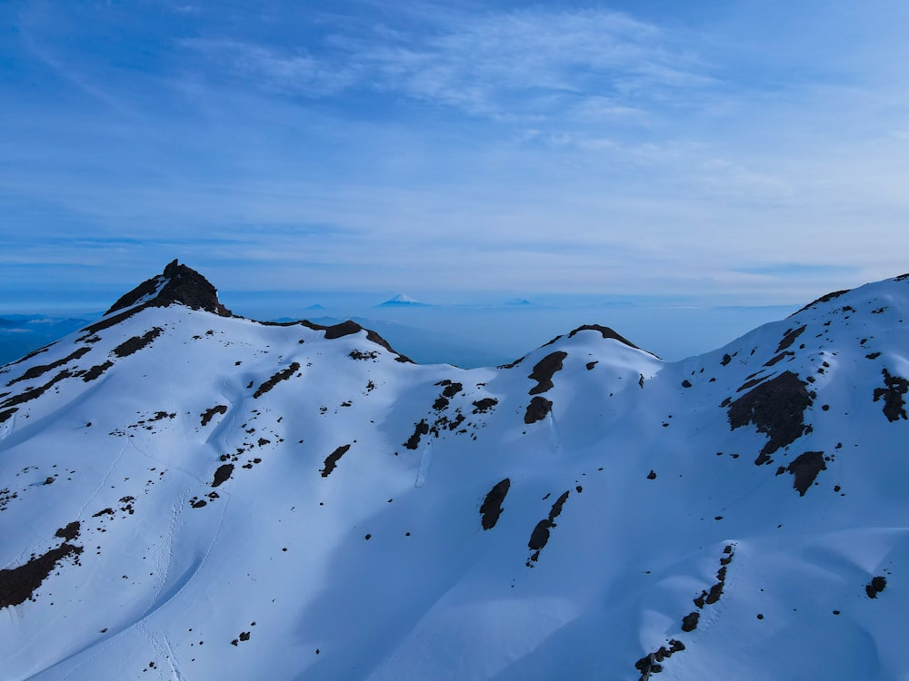 a mountain covered in snow under a blue sky