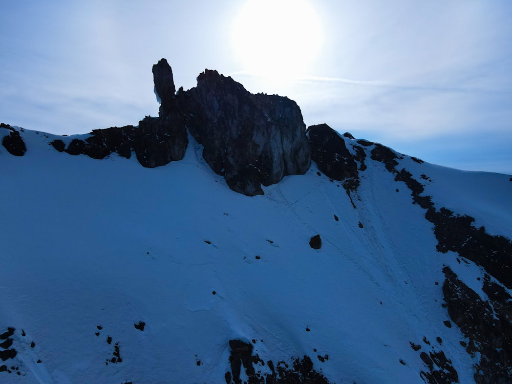 the sun is shining on a snowy mountain