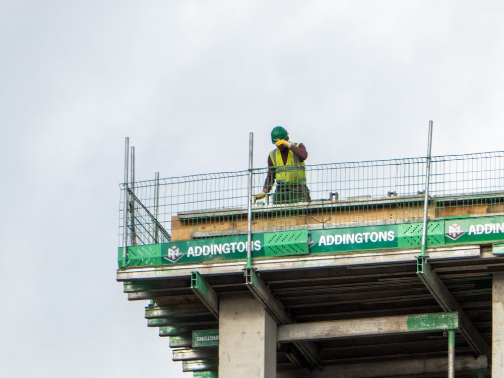 a construction worker standing on top of a bridge