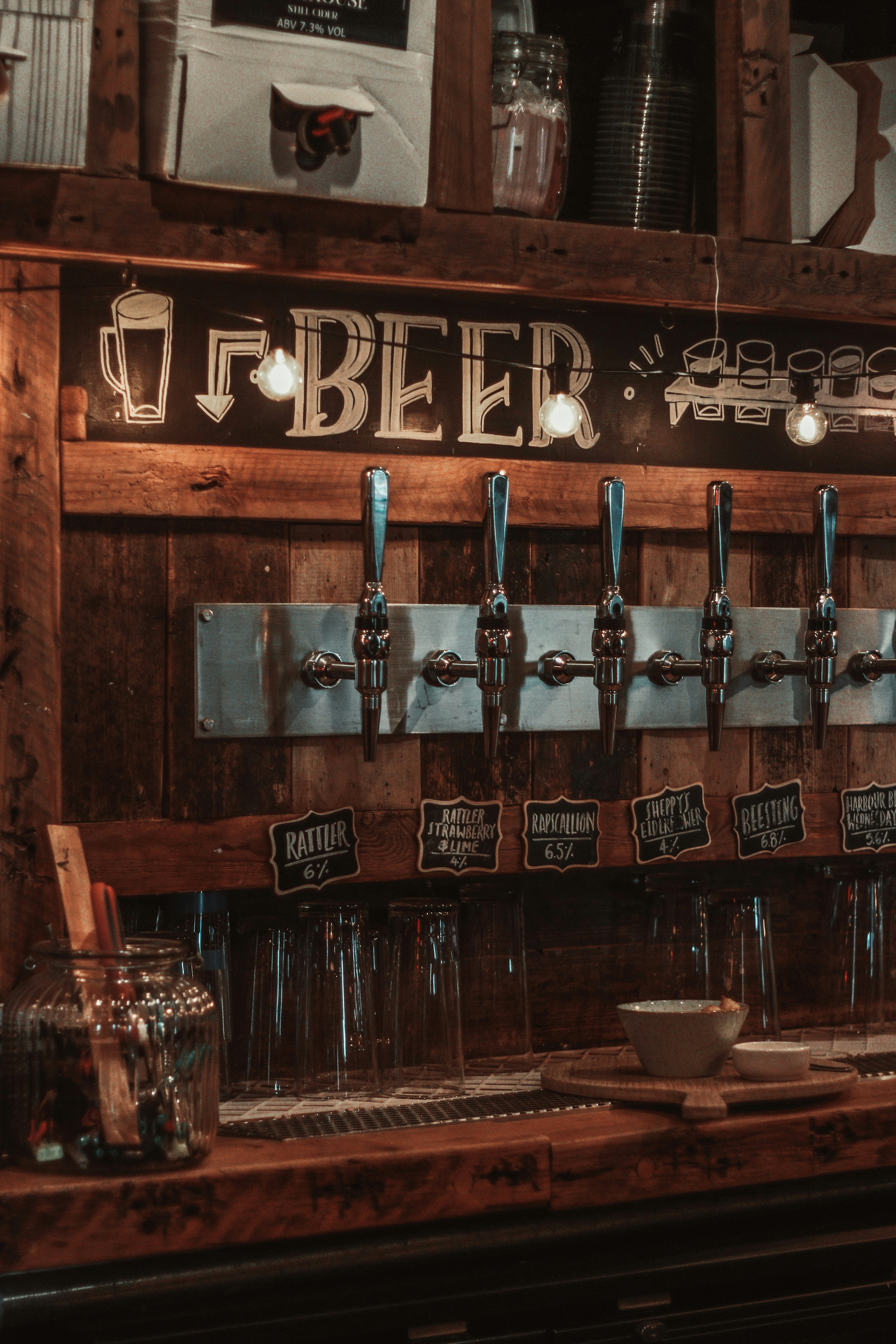 A row of beer taps on a wooden wall