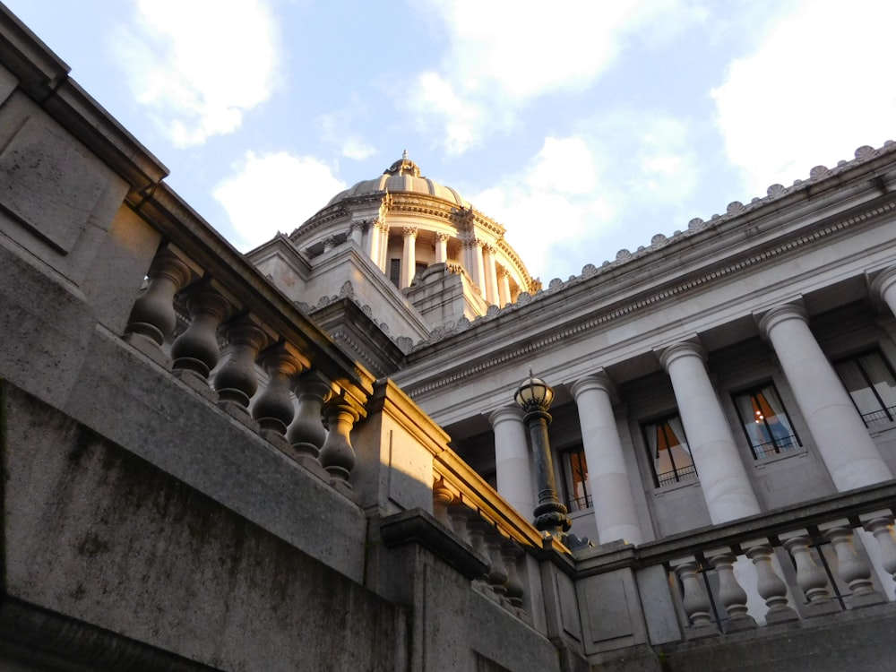 a building with columns and a clock tower in the background