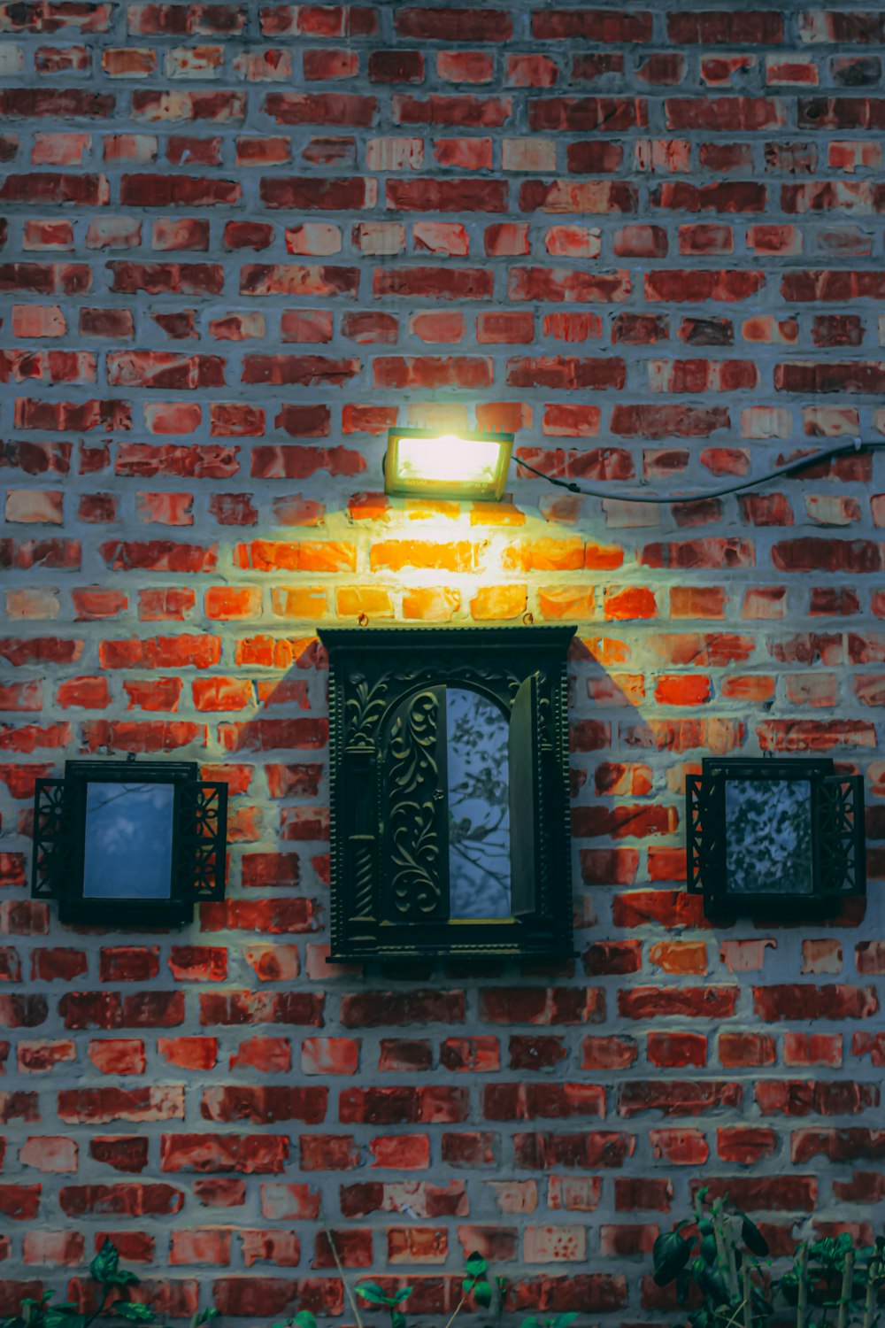 a brick wall with three square lights on it