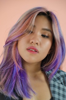 a woman with purple hair and a checkered shirt
