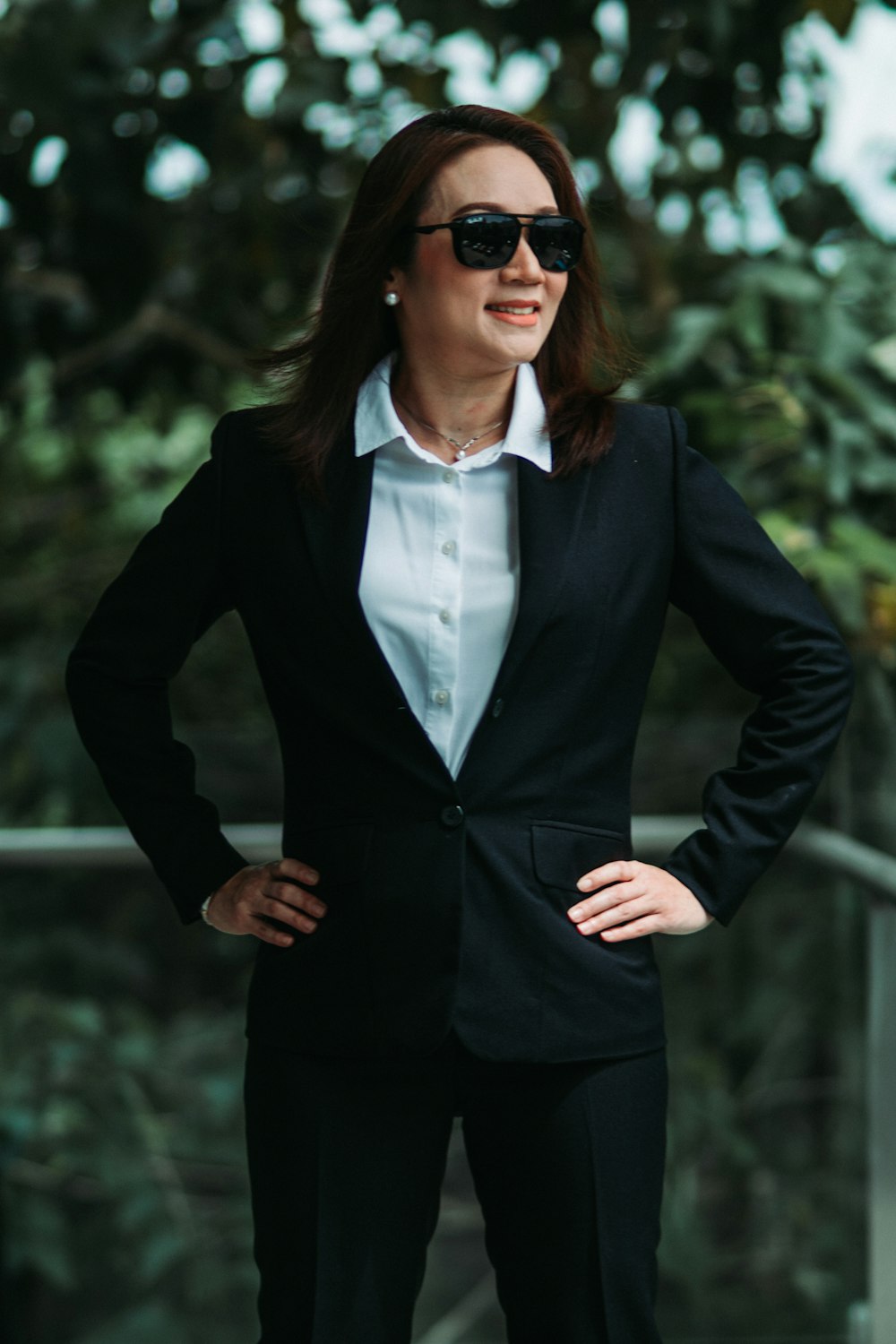 Une femme en costume et lunettes de soleil posant pour une photo