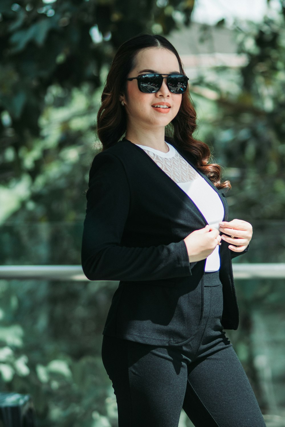 Une femme en costume noir et lunettes de soleil
