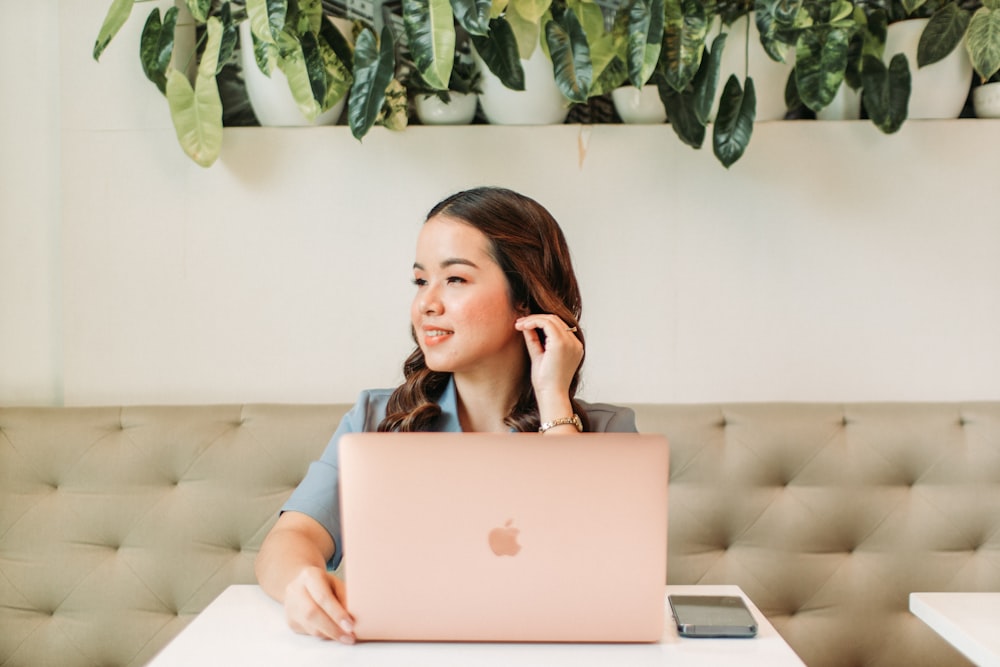 a woman sitting at a table with a laptop