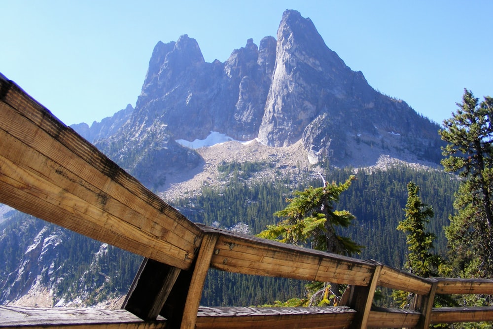 a wooden fence with a mountain in the background