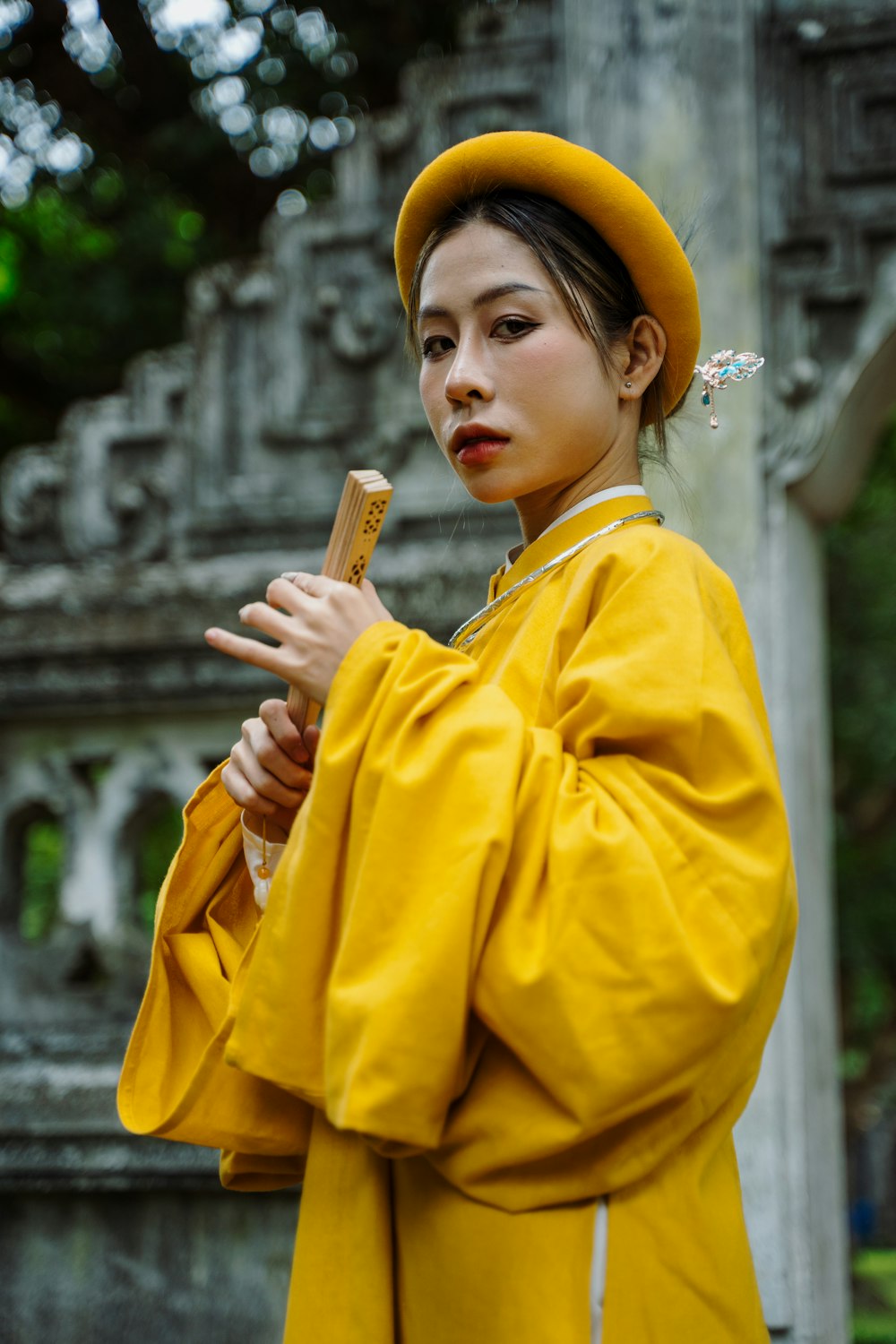 Eine Frau im gelben Outfit hält einen Stock