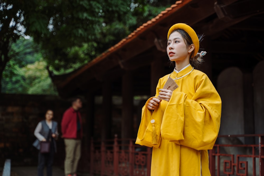 a woman in a yellow outfit standing in front of a building