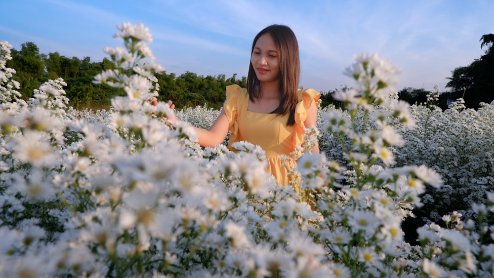 a woman standing in a field of white flowers