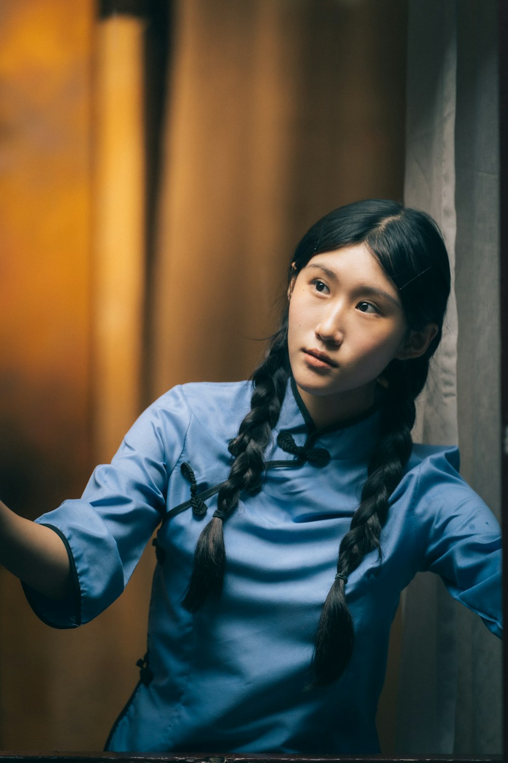 a woman in a blue shirt is holding a cell phone