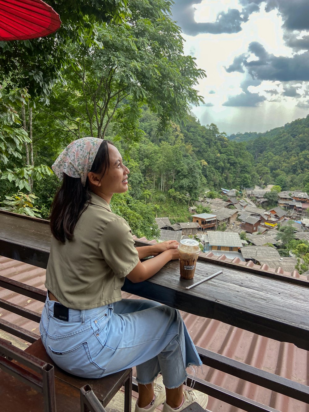 a woman sitting on a bench looking out over a valley
