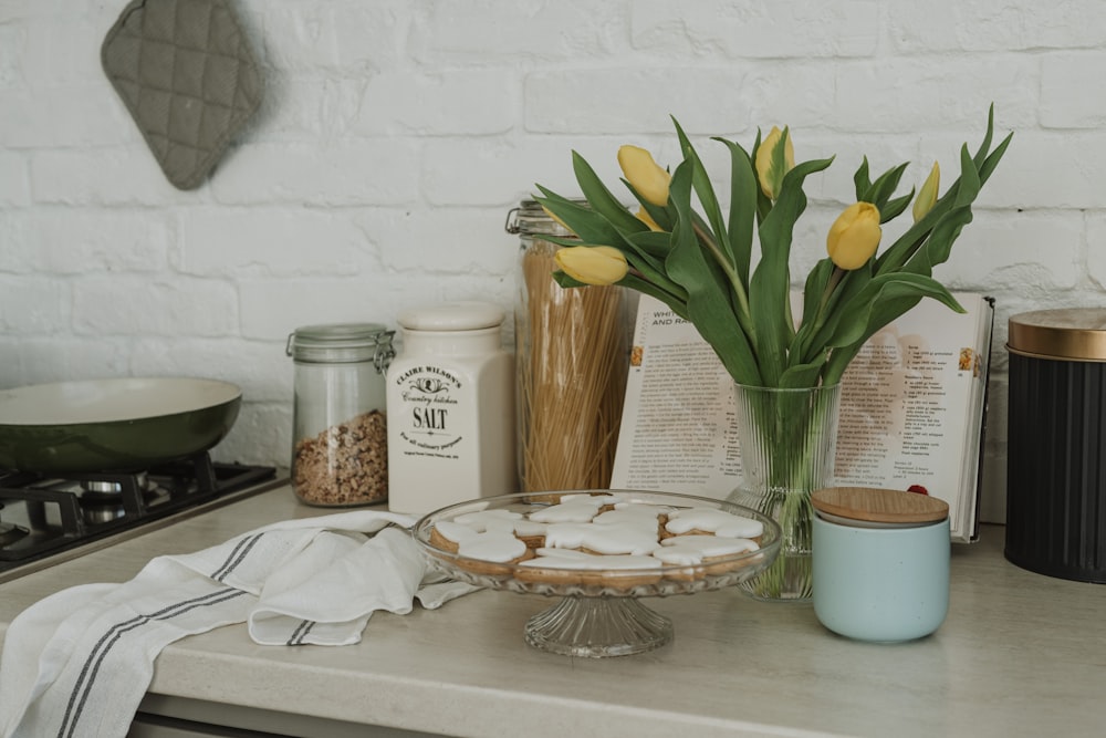 una mesa cubierta con un tazón de comida y un jarrón lleno de flores