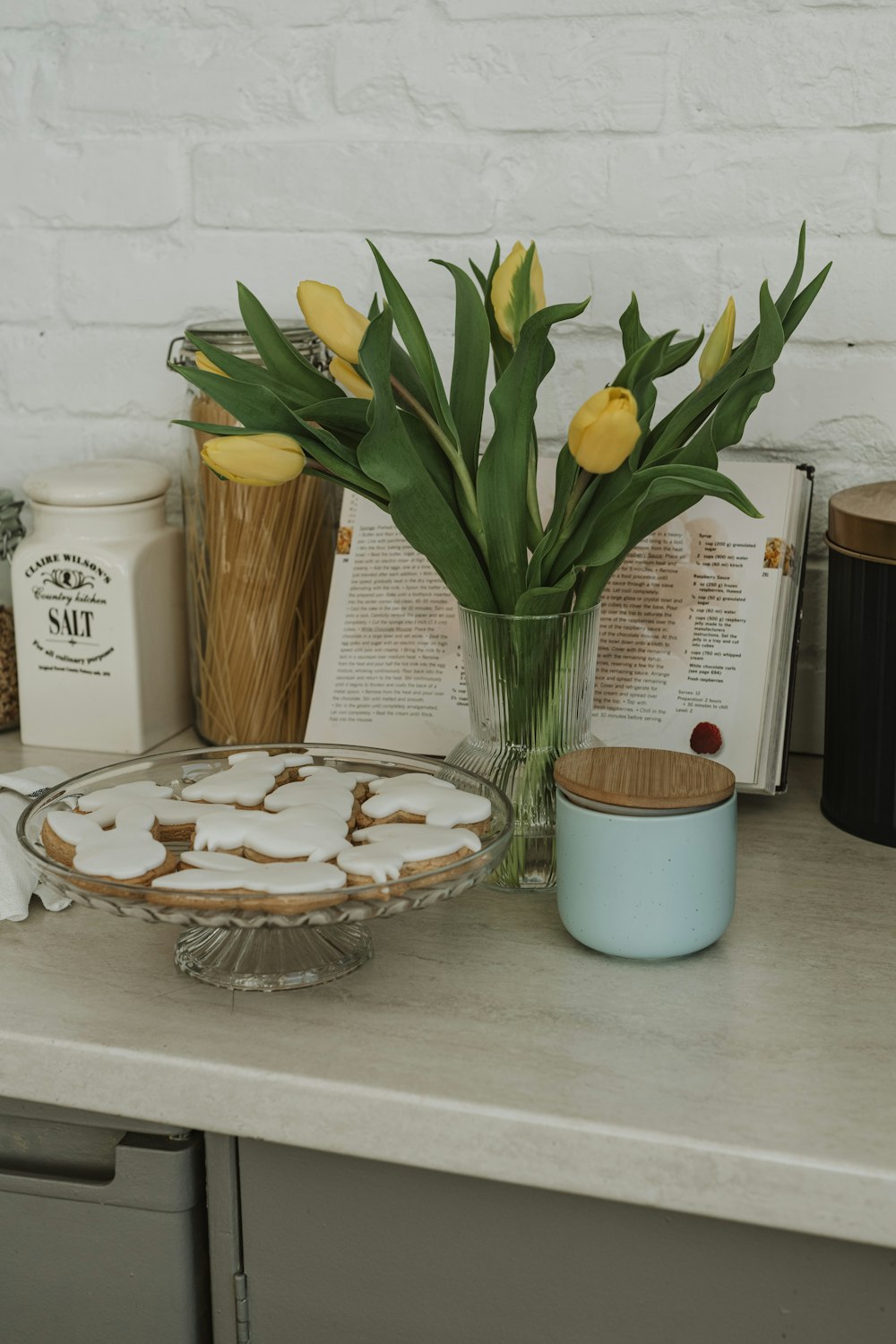 a table topped with a pie and a vase filled with flowers